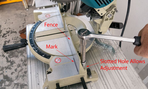 The fence of the mitre saw being adjusted.