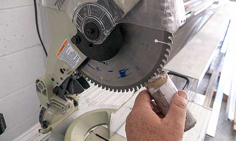 The fence of the mitre saw being adjusted.