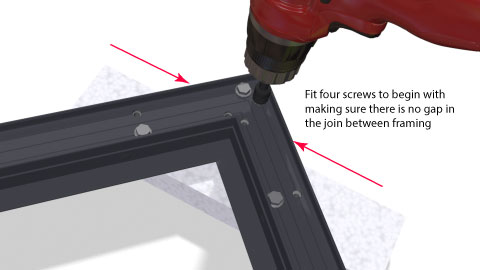 Close shot of the corner bracket being screwed up showing the pattern of screws and the builders square